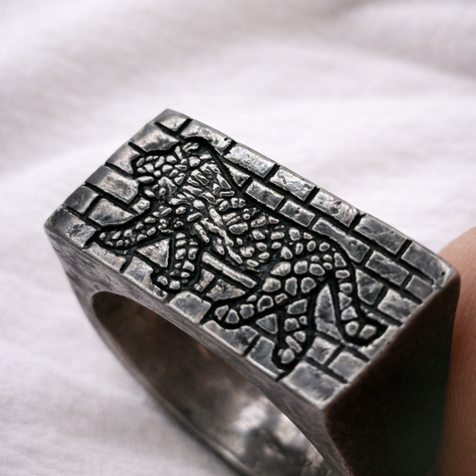 Silver ring with detailed design on a white background