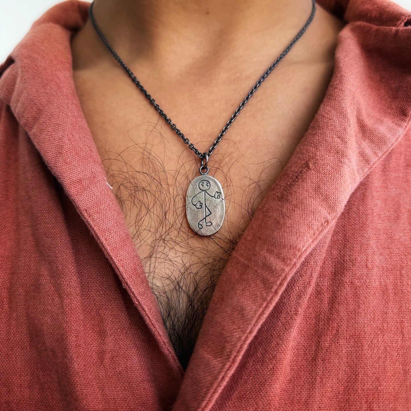 Necklace with a pendant worn by a person in a red garment