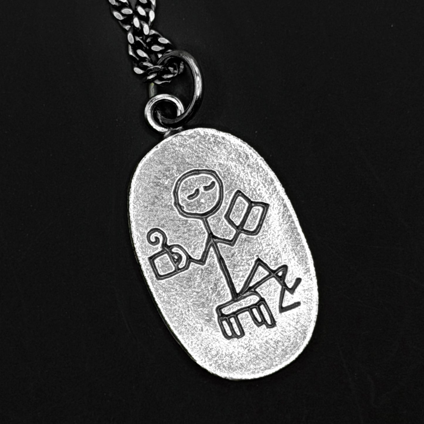 Silver pendant with a unique design on a black background