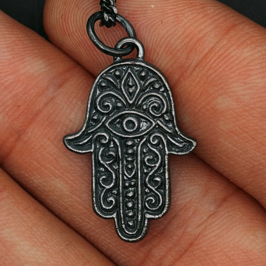 Silver Hamsa hand pendant on a finger