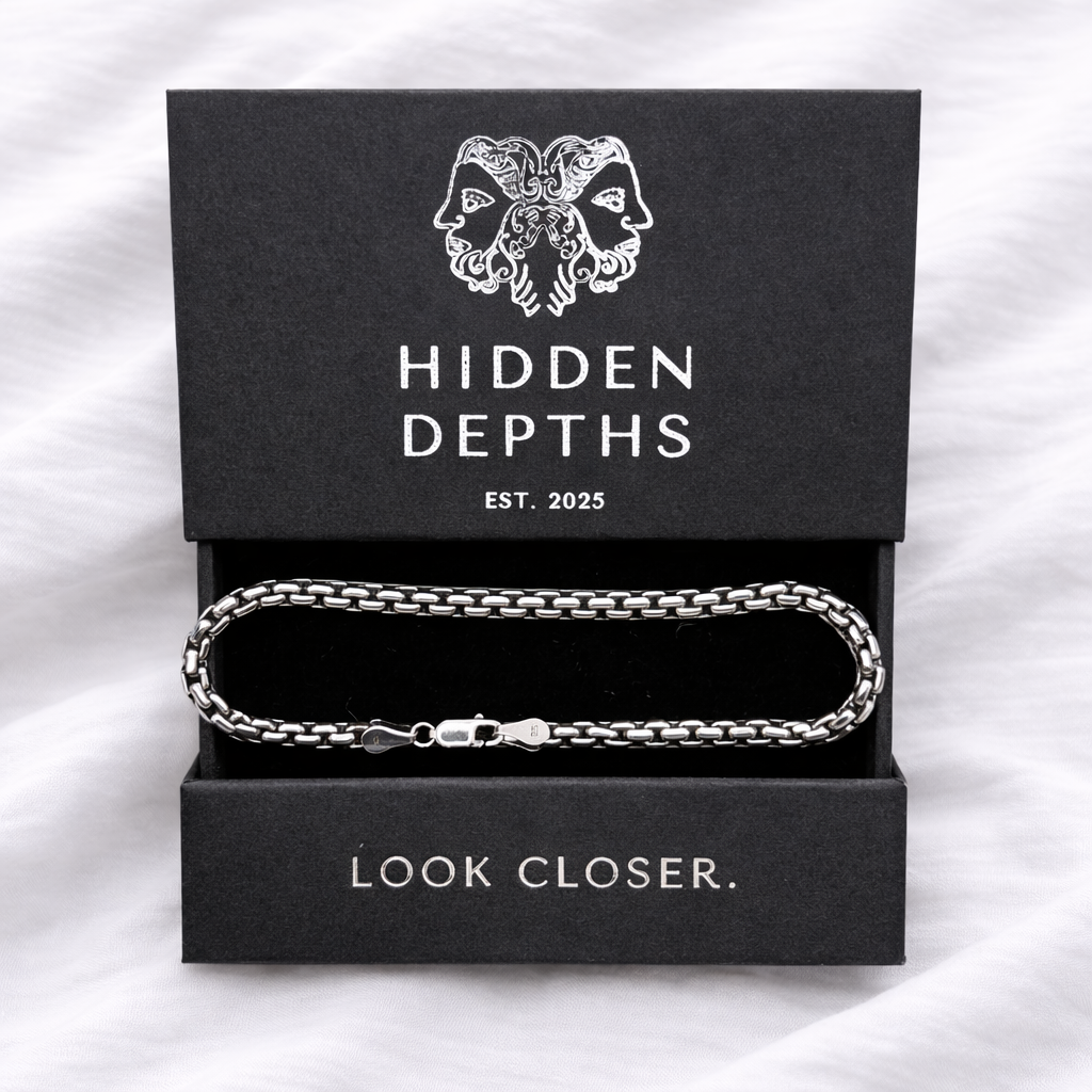 Silver chain bracelet in a 'Hidden Depths' jewelry box on a white background