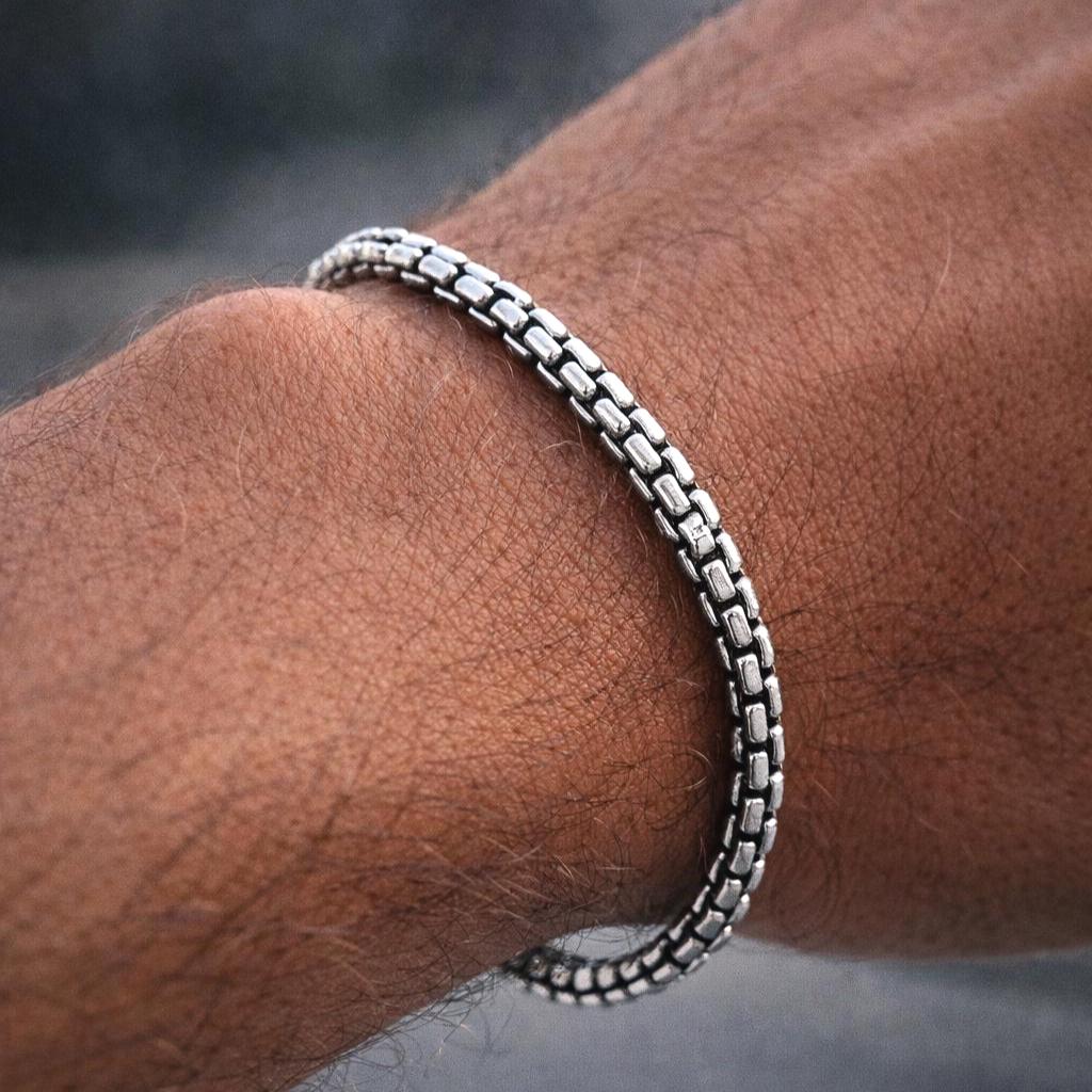 Silver bracelet on a wrist with a blurred background