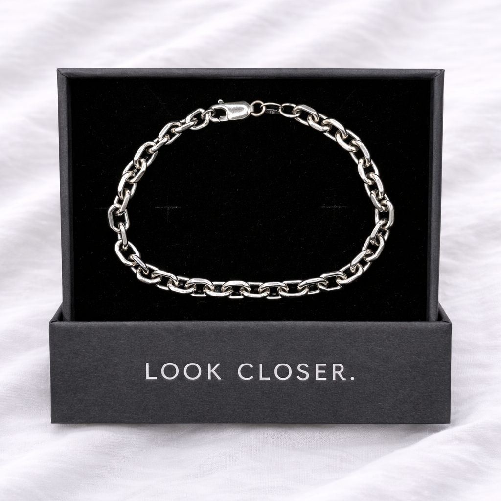 Silver chain bracelet in a black box with 'LOOK CLOSER.' text on a white background