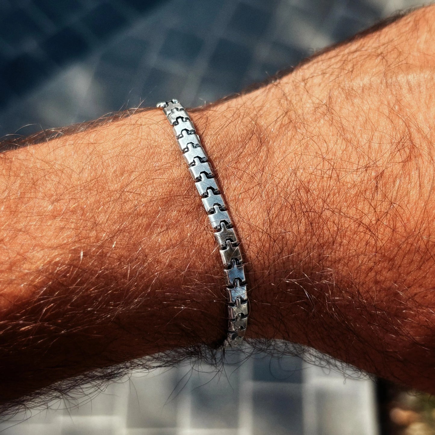 Silver bracelet on a wrist with a blurred background