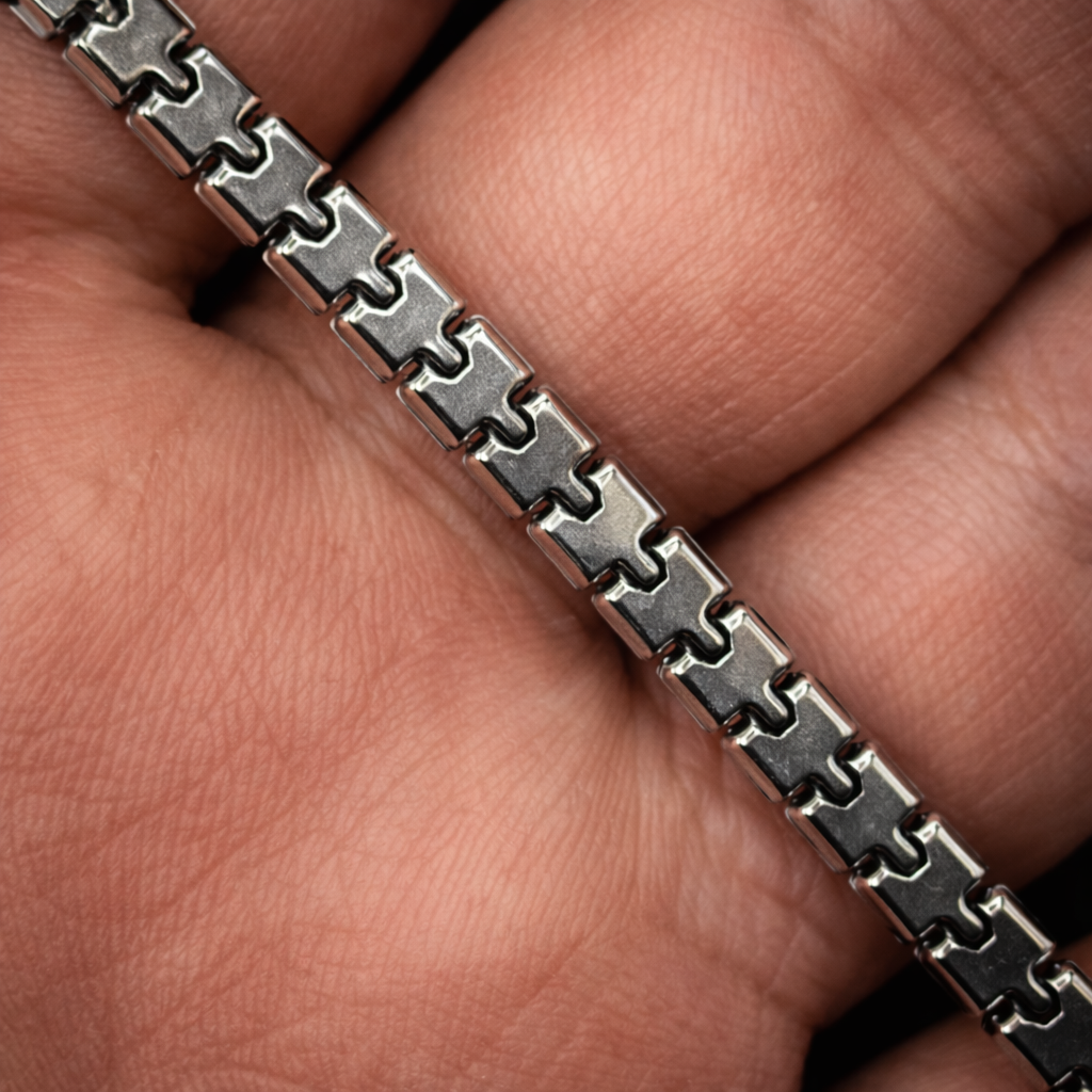 Close-up of a hand wearing a silver chain bracelet.