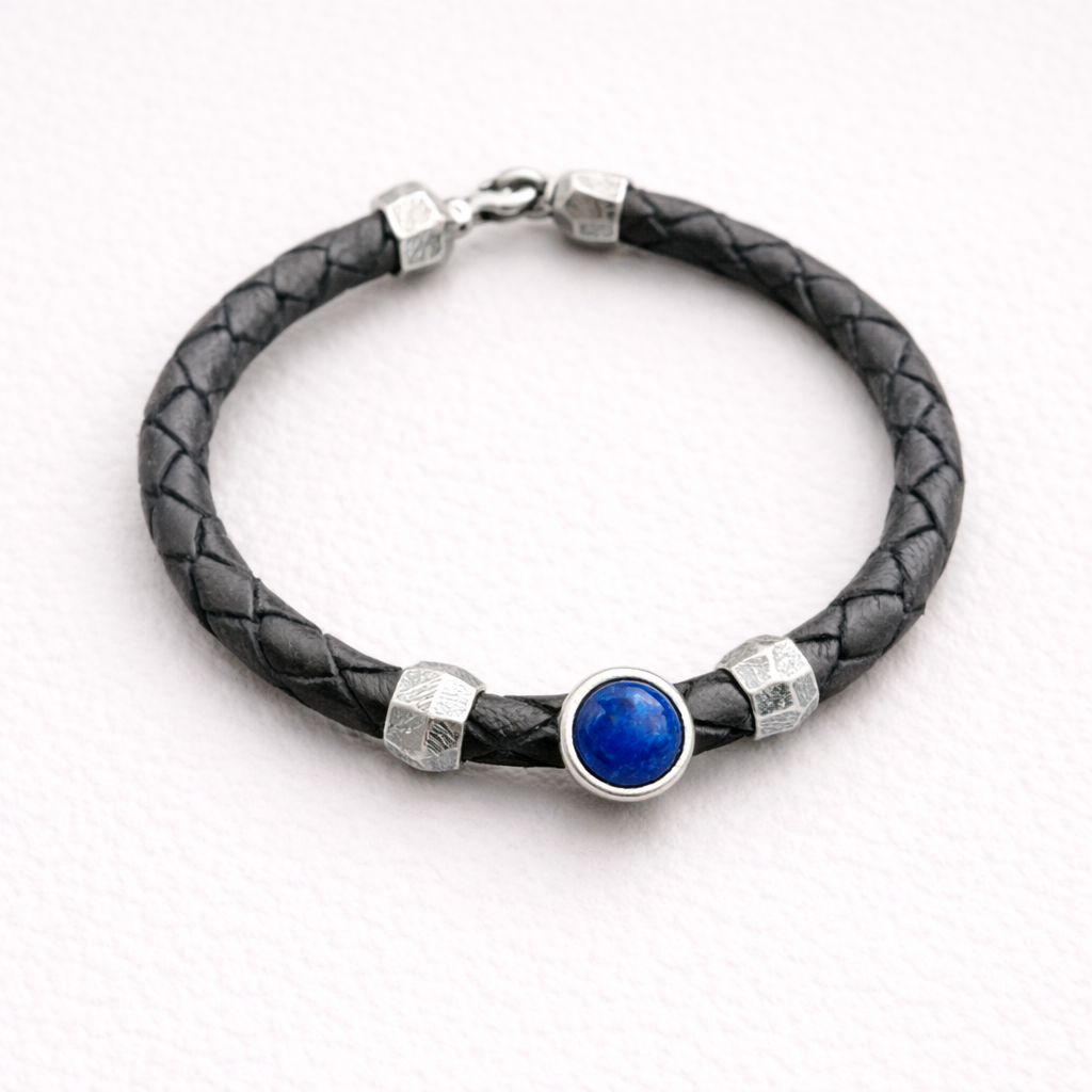 Black braided leather bracelet with a blue stone and silver accents on a white background