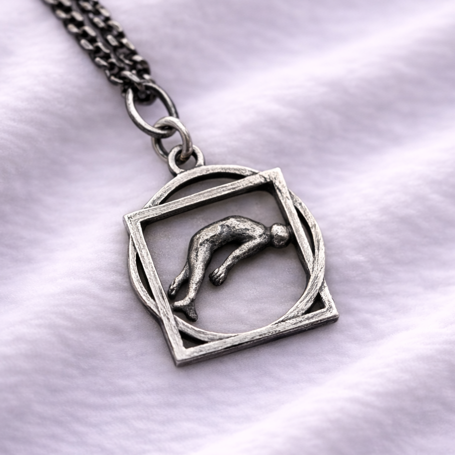Silver pendant with a man design on a white fabric background